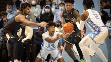 Jan 26, 2022; Chapel Hill, North Carolina, USA; North Carolina Tar Heels guard Puff Johnson (14) passes the ball to guard Caleb Love (2) as Boston College Eagles forward T.J. Bickerstaff (1) and guard Brevin Galloway (51) defend in the second half at Dean E. Smith Center. Mandatory Credit: Bob Donnan-USA TODAY Sports