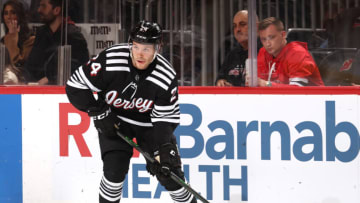NEWARK, NEW JERSEY - MARCH 22: Ty Smith #24 of the New Jersey Devils takes the puck during the first period against the New York Rangers at Prudential Center on March 22, 2022 in Newark, New Jersey. (Photo by Elsa/Getty Images)