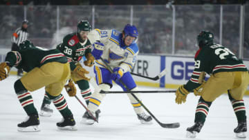 MINNEAPOLIS, MINNESOTA - JANUARY 01: Vladimir Tarasenko #91 of the St. Louis Blues skates with the puck as Dmitry Kulikov #29 and Ryan Hartman #38 of the Minnesota Wild defend in the second period during the NHL Winter Classic at Target Field on January 01, 2022 in Minneapolis, Minnesota. (Photo by David Berding/Getty Images)