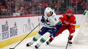 DETROIT, MICHIGAN - OCTOBER 16: J.T. Miller #9 of the Vancouver Canucks battles for the puck against Filip Hronek #17 of the Detroit Red Wings during the first period at Little Caesars Arena on October 16, 2021 in Detroit, Michigan. (Photo by Gregory Shamus/Getty Images)