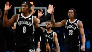 NEW YORK, NEW YORK - DECEMBER 14: David Duke Jr. #6, Patty Mills #8, and Nic Claxton #33 of the Brooklyn Nets high-five the bench during overtime against the Toronto Raptors at Barclays Center on December 14, 2021 in the Brooklyn borough of New York City. The Nets won 131-129. NOTE TO USER: User expressly acknowledges and agrees that, by downloading and or using this photograph, User is consenting to the terms and conditions of the Getty Images License Agreement. (Photo by Sarah Stier/Getty Images)
