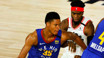 LAKE BUENA VISTA, FLORIDA - AUGUST 14: PJ Dozier #35 of the Denver Nuggets drives the ball past Terence Davis #0 of the Toronto Raptors during the second quarter at The Field House at ESPN Wide World Of Sports Complex on August 14, 2020 in Lake Buena Vista, Florida. NOTE TO USER: User expressly acknowledges and agrees that, by downloading and or using this photograph, User is consenting to the terms and conditions of the Getty Images License Agreement. (Photo by Mike Ehrmann/Getty Images)