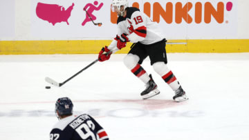 WASHINGTON, DC - FEBRUARY 21: Travis Zajac #19 of the New Jersey Devils skates with puck in front of Evgeny Kuznetsov #92 of the Washington Capitals in the second period at Capital One Arena on February 21, 2021 in Washington, DC. Zajac is playing in his 1,000th career NHL game. (Photo by Rob Carr/Getty Images)