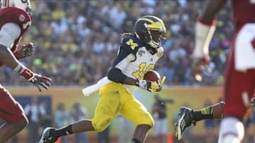 January 1,2013; Tampa, FL, USA; Michigan Wolverines quarterback Denard Robinson (16) runs against the South Carolina Gamecocks during the second half of the 2013 Outback Bowl at Raymond James Stadium. South Carolina Gamecocks defeated the Michigan Wolverines 33-28. Mandatory Credit: Kim Klement-USA TODAY Sports