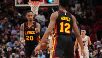 MIAMI, FLORIDA - JANUARY 14: John Collins #20 of the Atlanta Hawks points to De'Andre Hunter #12 after scoring a basket against the Miami Heat in the second half at FTX Arena on January 14, 2022 in Miami, Florida. NOTE TO USER: User expressly acknowledges and agrees that, by downloading and or using this photograph, User is consenting to the terms and conditions of the Getty Images License Agreement. (Photo by Mark Brown/Getty Images)