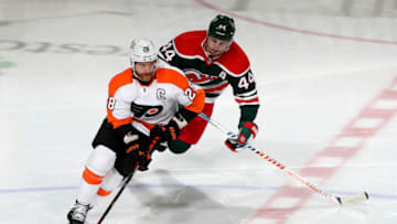 NEWARK, NEW JERSEY - APRIL 27: Claude Giroux #28 of the Philadelphia Flyers takes the puck as Miles Wood #44 of the New Jersey Devils defends in the third period at Prudential Center on April 27, 2021 in Newark, New Jersey.The New Jersey Devils defeated the Philadelphia Flyers 6-4. (Photo by Elsa/Getty Images)