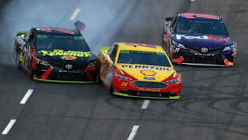 MARTINSVILLE, VA - OCTOBER 28: Joey Logano, driver of the #22 Shell Pennzoil Ford, and Martin Truex Jr., driver of the #78 5-hour ENERGY/Bass Pro Shops Toyota, make contact ahead of Denny Hamlin, driver of the #11 FedEx Freight Toyota, as they race to the finish line during the Monster Energy NASCAR Cup Series First Data 500 at Martinsville Speedway on October 28, 2018 in Martinsville, Virginia. (Photo by Sean Gardner/Getty Images)