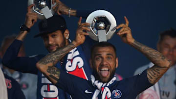 Paris Saint-Germain's Brazilian forward Neymar and Paris Saint-Germain's Brazilian defender Dani Alves (R) celebrate with their Champion's trophy at the end of the French L1 football match between Paris Saint-Germain (PSG) and Dijon at the Parc des Princes stadium in Paris on May 18, 2019. (Photo by FRANCK FIFE / AFP) (Photo credit should read FRANCK FIFE/AFP/Getty Images)