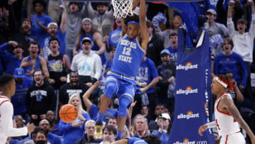 Feb 26, 2023; Memphis, Tennessee, USA; Memphis Tigers forward DeAndre Williams (12) hangs on the rim after dunk during the second half against the Cincinnati Bearcats at FedExForum. Mandatory Credit: Petre Thomas-USA TODAY Sports