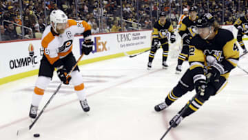 Nov 4, 2021; Pittsburgh, Pennsylvania, USA; Philadelphia Flyers center Claude Giroux (28) moves the puck against Pittsburgh Penguins right wing Kasperi Kapanen (42) during the third period at PPG Paints Arena. Mandatory Credit: Charles LeClaire-USA TODAY Sports