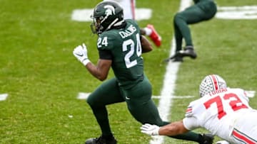 Michigan State's Elijah Collins runs for a gain as Ohio State's Tommy Togiai attempts the tackle during the first quarter on Saturday, Dec. 5, 2020, at Spartan Stadium in East Lansing.201205 Msu Osu 072a