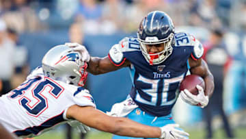 NASHVILLE, TN - AUGUST 17: Jeremy McNichols #30 of the Tennessee Titans stiff arms Trent Harris #45 of the New England Patriots during week two of preseason at Nissan Stadium on August 17, 2019 in Nashville, Tennessee. (Photo by Wesley Hitt/Getty Images)