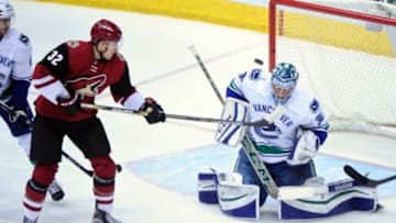 Feb 10, 2016; Glendale, AZ, USA; Vancouver Canucks goalie Ryan Miller (30) makes a save on Arizona Coyotes center Tyler Gaudet (32) during the first period at Gila River Arena. Mandatory Credit: Matt Kartozian-USA TODAY Sports