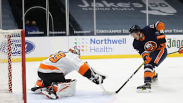 UNIONDALE, NEW YORK - MARCH 20: Mathew Barzal #13 of the New York Islanders shoots against Carter Hart #79 of the Philadelphia Flyers during their game at Nassau Coliseum on March 20, 2021 in Uniondale, New York. (Photo by Al Bello/Getty Images)