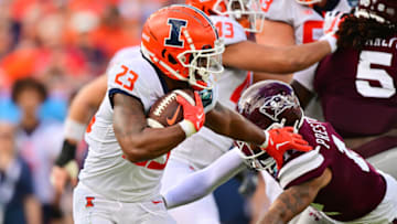 TAMPA, FLORIDA - JANUARY 02: Reggie Love III #23 of the Illinois Fighting Illini breaks a tackle from Shawn Preston Jr. #12 of the Mississippi State Bulldogs in the second quarter during the ReliaQuest Bowl at Raymond James Stadium on January 02, 2023 in Tampa, Florida. (Photo by Julio Aguilar/Getty Images)