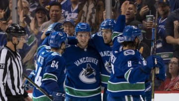 VANCOUVER, BC - OCTOBER 3: Jake Virtanen #18 of the Vancouver Canucks is congratulated by teammates Tyler Motte #64, Brandon Sutter #20 and Chris Tanev #8 after scoring a goal against the Calgary Flames in NHL action on October, 3, 2018 at Rogers Arena in Vancouver, British Columbia, Canada. (Photo by Rich Lam/Getty Images)