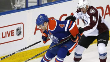 Mar 25, 2015; Edmonton, Alberta, CAN; Edmonton Oilers forward Taylor Hall (4) and Colorado Avalanche defensemen Tyson Barrie (4) battle for a loose puck during the first period at Rexall Place. Mandatory Credit: Perry Nelson-USA TODAY Sports