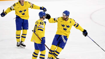 Sweden's defender Adam Larsson (R) celebrates scoring the opening goal with his teammates Jacob Peterson (C) and Rasmus Dahlin (L) during the IIHF Ice Hockey World Championships 1st Round group B match between Finland and Sweden at the Nokia Arena in Tampere, Finland, on May 18, 2022. - - Finland OUT (Photo by Heikki Saukkomaa / Lehtikuva / AFP) / Finland OUT (Photo by HEIKKI SAUKKOMAA/Lehtikuva/AFP via Getty Images)