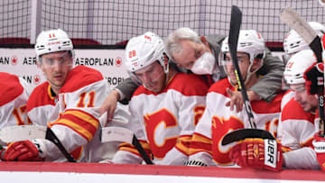 MONTREAL, QC - APRIL 14: Head coach Darryl Sutter of the Calgary Flames speaks with Elias Lindholm #28 and Johnny Gaudreau #13 during the third period against the Montreal Canadiens at the Bell Centre on April 14, 2021 in Montreal, Canada. The Flames defeated the Canadiens 4-1. (Photo by Minas Panagiotakis/Getty Images)
