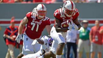 RALEIGH, NORTH CAROLINA - AUGUST 31: Zonovan Knight #24 of the North Carolina State Wolfpack breaks away from Bruce Bivens #38 of the East Carolina Pirates for a touchdown during the first half of their game at Carter-Finley Stadium on August 31, 2019 in Raleigh, North Carolina. (Photo by Grant Halverson/Getty Images)