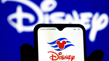 UKRAINE - 2022/01/26: In this photo illustration, the Disney Cruise Line logo is seen displayed on a smartphone screen with the Disney logo in the background. (Photo Illustration by Igor Golovniov/SOPA Images/LightRocket via Getty Images)