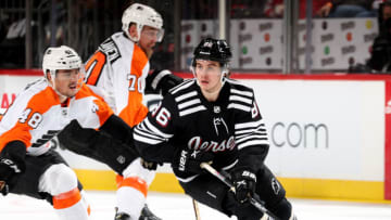 NEWARK, NEW JERSEY - DECEMBER 08: Jack Hughes #86 of the New Jersey Devils takes the puck as Morgan Frost #48 of the Philadelphia Flyers defends during the third period at Prudential Center on December 08, 2021 in Newark, New Jersey. Tonight the New Jersey Devils are wearing their newly designed third jersey. The New Jersey Devils shut out the Philadelphia Flyers 3-0. (Photo by Elsa/Getty Images)