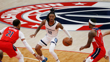 Nov 5, 2021; Washington, District of Columbia, USA; Memphis Grizzlies guard Ja Morant (12) dribbles the ball between Washington Wizards center Daniel Gafford (21) and Wizards guard Kentavious Caldwell-Pope (1) during the first quarter at Capital One Arena. Mandatory Credit: Amber Searls-USA TODAY Sports