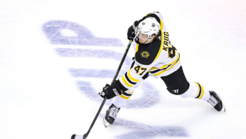 Torey Krug #47 of the Boston Bruins attempts a shot against the Carolina Hurricanes. (Photo by Elsa/Getty Images)