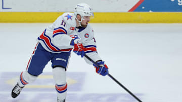 SYRACUSE, NY - APRIL 21: Lukas Rousek #11 of Rochester Americans passes the puck against the Syracuse Crunch at Upstate Medical University Arena on April 21, 2023 in Syracuse, New York. (Photo by Isaiah Vazquez/Getty Images)