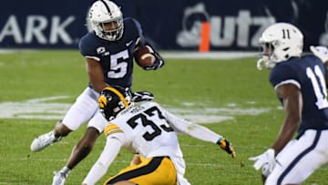 Nov 21, 2020; University Park, Pennsylvania, USA; Penn State Nittany Lions wide receiver Jahan Dotson (5) avoids the tackle attempt of Iowa Hawkeyes defensive back Riley Moss (33) while running with the ball after a catch during the second quarter at Beaver Stadium. Mandatory Credit: Rich Barnes-USA TODAY Sports