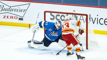 Feb 1, 2021; Winnipeg, Manitoba, CAN; Calgary Flames forward Johnny Gaudreau (13) scores the game-winning goal against Winnipeg Jets goalie Connor Hellebuyck (37) during the shoot out period at Bell MTS Place. Mandatory Credit: Terrence Lee-USA TODAY Sports