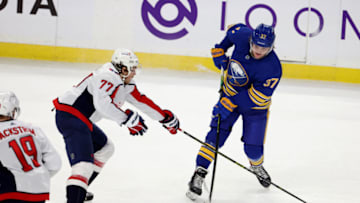 Mar 15, 2021; Buffalo, New York, USA; Washington Capitals right wing T.J. Oshie (77) tries to block a shot by Buffalo Sabres center Casey Mittelstadt (37) during the second period at KeyBank Center. Mandatory Credit: Timothy T. Ludwig-USA TODAY Sports