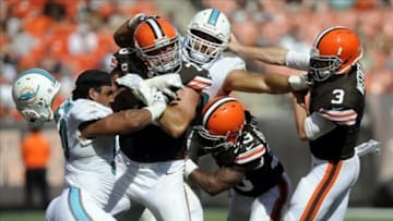 Sep 8, 2013; Cleveland, OH, USA; Cleveland Browns quarterback Brandon Weeden (3) has his face mask grabbed by Miami Dolphins defensive end Jared Odrick (98) as Cleveland Browns tackle Joe Thomas (73) and Cleveland Browns running back Trent Richardson (33) try to block Miami Dolphins defensive end Olivier Vernon (50) during the fourth quarter at FirstEnergy Stadium. Mandatory Credit: Ken Blaze-USA TODAY Sports