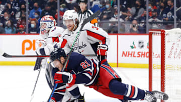 Dec 17, 2021; Winnipeg, Manitoba, CAN; Washington Capitals defenseman Nick Jensen (3) checks Winnipeg Jets center Dominic Toninato (21) in the second period at Canada Life Centre. Mandatory Credit: James Carey Lauder-USA TODAY Sports