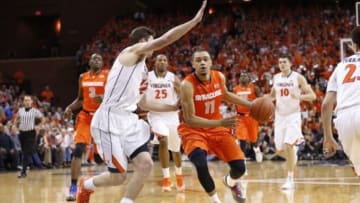Mar 1, 2014; Charlottesville, VA, USA; Syracuse Orange guard Tyler Ennis (11) dribbles the ball as Virginia Cavaliers guard Joe Harris (12) defends in the first half at John Paul Jones Arena. Mandatory Credit: Geoff Burke-USA TODAY Sports