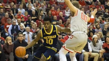 Feb 16, 2016; Columbus, OH, USA; Michigan Wolverines guard Derrick Walton Jr. (10) cuts underneath defending Ohio State Buckeyes forward Mickey Mitchell (00) at Value City Arena. Ohio State won the game 76-66. Mandatory Credit: Greg Bartram-USA TODAY Sports