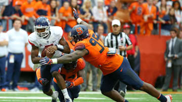 SYRACUSE, NY - SEPTEMBER 22: David Pindell #5 of the Connecticut Huskies runs with the ball while being tackled by Alton Robinson (back) and Chris Slayton #95 of the Syracuse Orange during the first quarter at the Carrier Dome on September 22, 2018 in Syracuse, New York. Syracuse defeated Connecticut 51-21. (Photo by Rich Barnes/Getty Images)