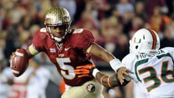 Nov 2, 2013; Tallahassee, FL, USA; Florida State Seminoles quarterback Jameis Winston (5) evades Miami Hurricanes linebacker Alex Figueroa (36) during the second half at Doak Campbell Stadium. Mandatory Credit: Melina Vastola-USA TODAY Sports