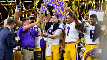 NEW ORLEANS, LOUISIANA - JANUARY 13: Head coach Ed Orgeron of the LSU Tigers raises the National Championship Trophy with Joe Burrow #9, Grant Delpit #7, and Patrick Queen #8 after the College Football Playoff National Championship game at the Mercedes Benz Superdome on January 13, 2020 in New Orleans, Louisiana. The LSU Tigers topped the Clemson Tigers, 42-25. (Photo by Alika Jenner/Getty Images)