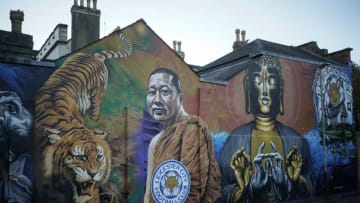 LEICESTER, ENGLAND - OCTOBER 29: People walk past a mural dedicated to Leicester City Football Club and Buddhist monk Phra Prommangkalachan on October 28, 2018 in Leicester, England. The city of Leicester is in mourning after Leicester City's Thai chairman Vichai Srivaddhanaprabha died in a helicopter crash alongside four others at the club's King Power Stadium on Saturday. (Photo by Christopher Furlong/Getty Images)