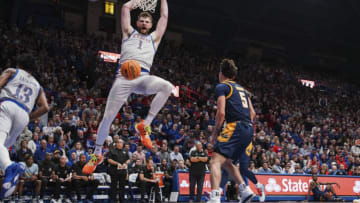 Dec 5, 2023; Lawrence, Kansas, USA; Kansas Jayhawks center Hunter Dickinson (1) dunks the ball as UMKC Kangaroos guard Jamar Brown (5) looks on during the first half at Allen Fieldhouse. Mandatory Credit: Denny Medley-USA TODAY Sports