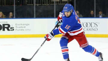Oct 27, 2014; New York, NY, USA; New York Rangers left wing Tanner Glass (15) sends the puck during the first period against the Minnesota Wild at Madison Square Garden. Mandatory Credit: Anthony Gruppuso-USA TODAY Sports