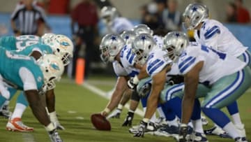 Aug 4, 2013; Canton, OH, USA; General view of the line of scrimmage as Dallas Cowboys quarterback Alex Tanney (7) takes the snap from center Phil Costa (67) in the 2013 Hall of Fame Game against the Miami Dolphins at Fawcett Stadium. The Cowboys defeated the Dolphins 24-20. Mandatory Credit: Kirby Lee-USA TODAY Sports