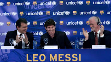 Barcelona's Argentinian forward Lionel Messi (C) aknowledges applause from Barcelona FC President Joan Laporta (L) and UN Children's Fund (UNICEF) Regional Director for the UNICEF Regional Office for Geneva, Philip O'Brien (R) (Photo credit JOSEP LAGO/AFP via Getty Images)