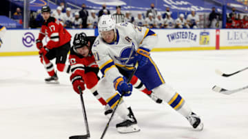 Feb 25, 2021; Buffalo, New York, USA; Buffalo Sabres right wing Kyle Okposo (21) drives to the net against New Jersey Devils defenseman Dmitry Kulikov (70) during the second period at KeyBank Center. Mandatory Credit: Timothy T. Ludwig-USA TODAY Sports