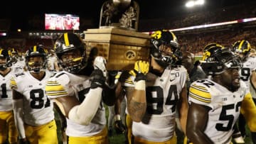AMES, IA - SEPTEMBER 14: Defensive end Chauncey Golston #57, left, and defensive end A.J. Epenesa #94 of the Iowa Hawkeyes carry the Iowa Corn Cy-Hawk Trophy off the field after winning 18-17 over the Iowa State Cyclones at Jack Trice Stadium on September 14, 2019 in Ames, Iowa. The Iowa Hawkeyes won 18-17 over the Iowa State Cyclones. (Photo by David Purdy/Getty Images)