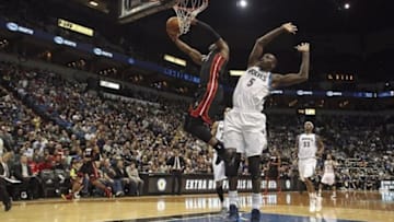 Dec 7, 2013; Minneapolis, MN, USA; Miami Heat shooting guard Dwyane Wade (3) goes up for a dunk past Minnesota Timberwolves center Gorgui Dieng (5) in the first half at Target Center. Mandatory Credit: Jesse Johnson-USA TODAY Sports