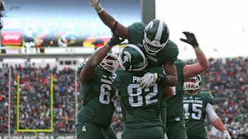 EAST LANSING, MI - NOVEMBER 19: LJ Scott #3 of the Michigan State Spartans celebrates a fourth quarter touchdown with his teammates during the game against the Ohio State Buckeyes at Spartan Stadium on November 19, 2016 in East Lansing, Michigan. Ohio State defeated Michigan State 17-16. (Photo by Leon Halip/Getty Images)