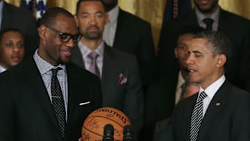 WASHINGTON, DC - JANUARY 28: U.S. President Barack Obama (R) is given a ball from LeBron James (L) during an event to honor the NBA champion Miami Heat in the East Room at the White House on January 28, 2013 in Washington, DC. President Barack Obama congratulated the 2012 NBA champions for claiming their third NBA Championship by beating the Boston Celtics. (Photo by Mark Wilson/Getty Images)