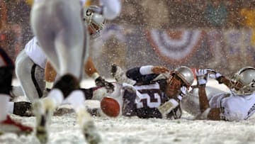 FOXBOROUGH, MA - JANUARY 19: Patriots quarterback Tom Brady loses the ball after being hit by the Oakland Raiders Charles Woodson, right, the fumble was recovered by Greg Biekert, left, but it was ruled an incomplete pass, giving the Patriots another chance. (Photo by Jim Davis/The Boston Globe via Getty Images)